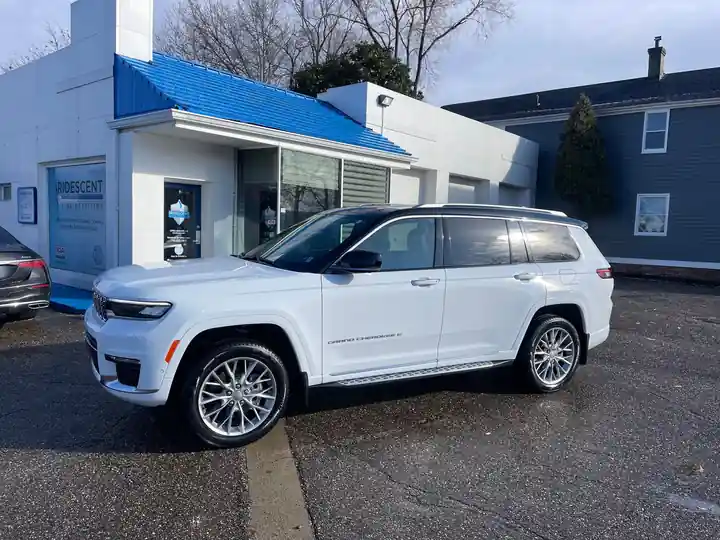 White Jeep Grand Cherokee L outside the shop with the blue roof